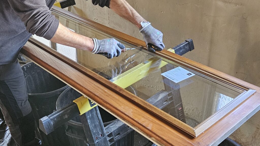 découpe une vitre sur cadre en bois